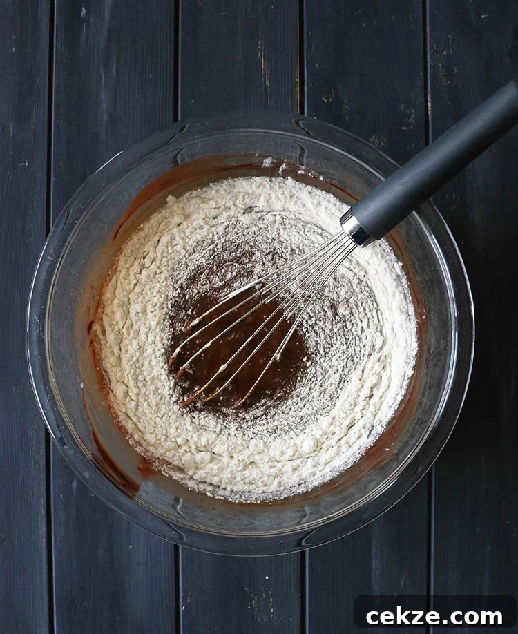 Whisking flour into chocolate cake batter