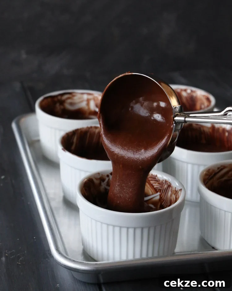 scooping spicy molten chocolate lava cake batter into white ramekins