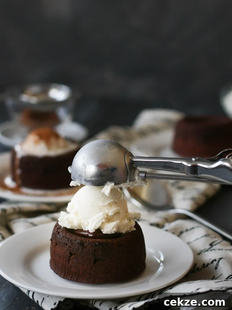 a scoop of vanilla ice cream being placed on top of a Spicy Molten Chocolate Lava Cake
