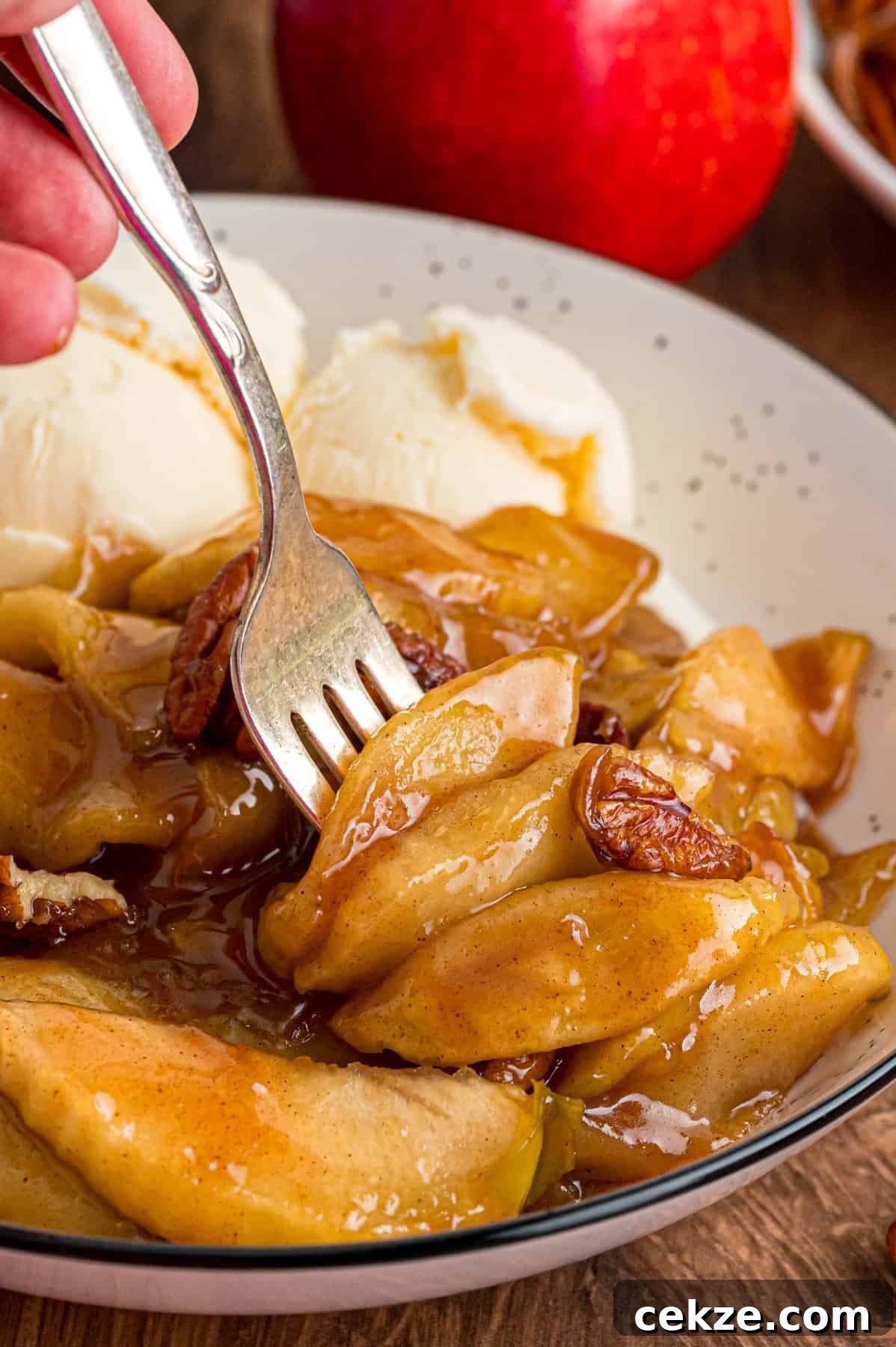Granny Smith apple slices are tossed with sugar and spices then baked until tender in this Baked Apples recipe. Serve with ice cream. A fork in baked apple slices