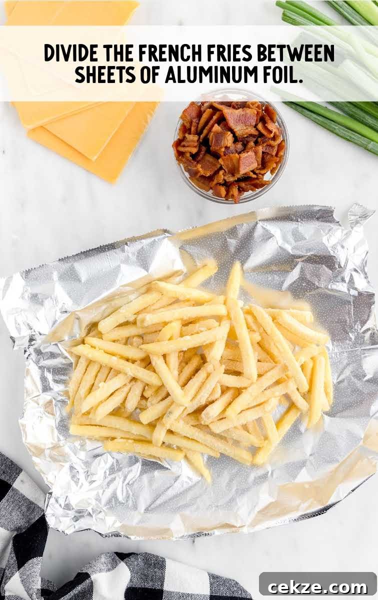 Loaded Dirty Fries Recipe: Crispy Fries Topped with Cheese & Bacon 5 French fries placed on a sheet of aluminum foil