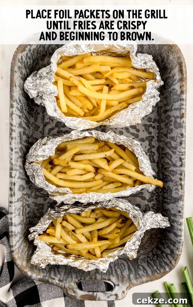 Loaded Dirty Fries Recipe: Crispy Fries Topped with Cheese & Bacon 7 aluminum foiled wrapped fries placed on a pan