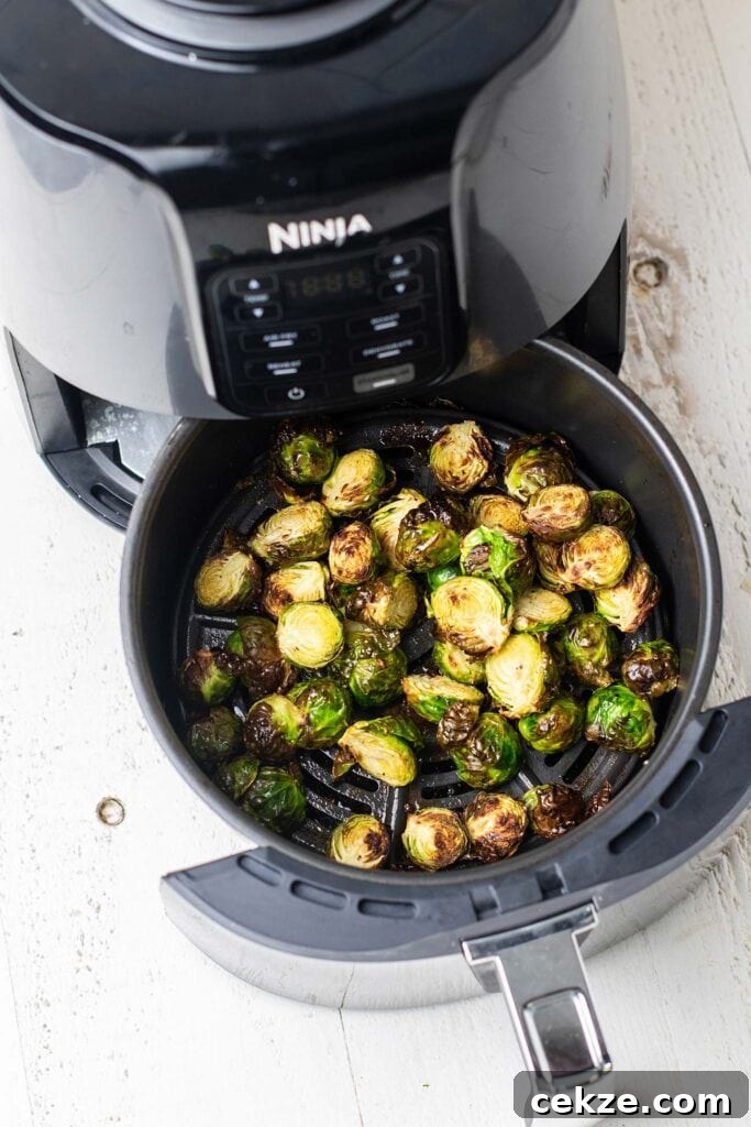 Brussels sprouts shown in an air fryer.