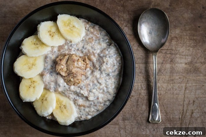 No-Cook Overnight Oats Recipe for Camping Breakfast 3 overnight oats with banana and peanut butter in a black bowl with a spoon on a table top