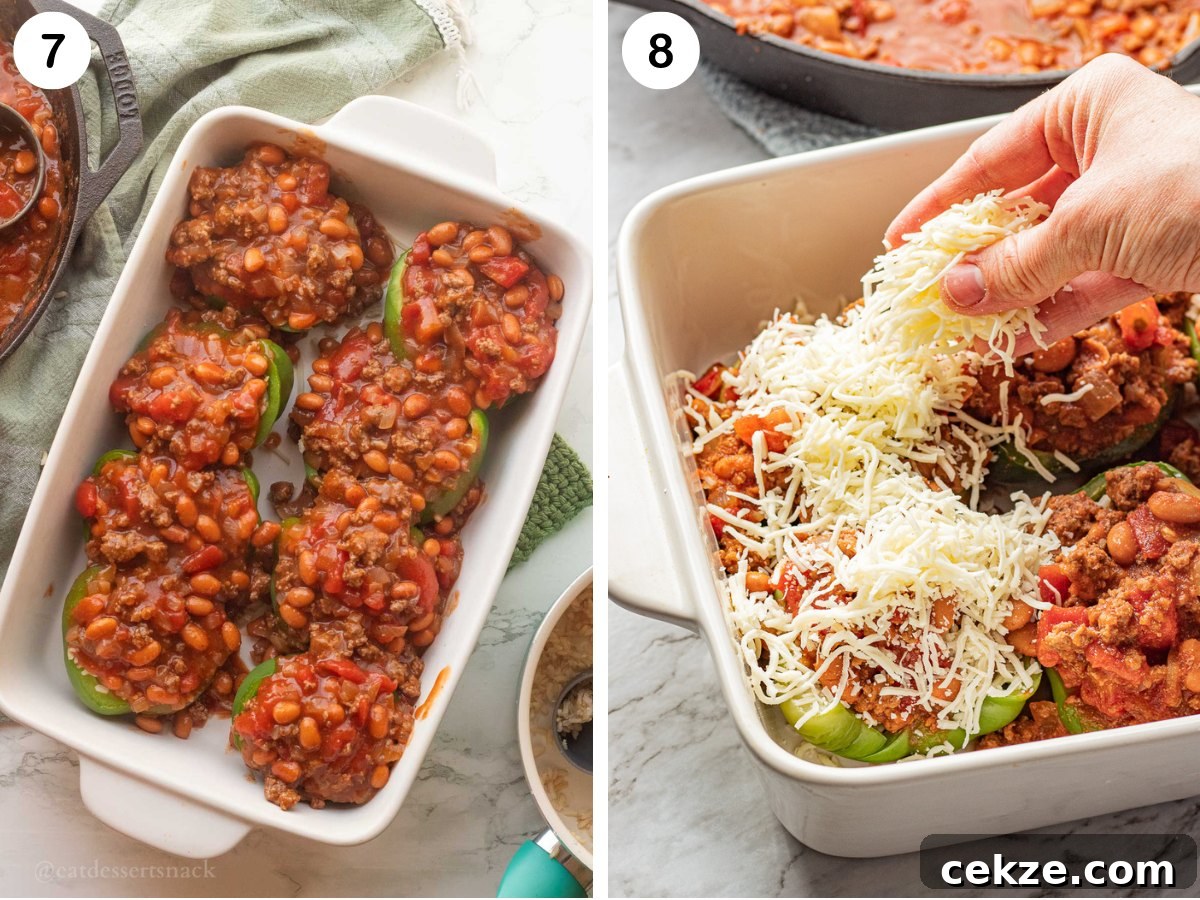 Green pepper halves with filling on top, and hand sprinkling cheese on top of peppers.