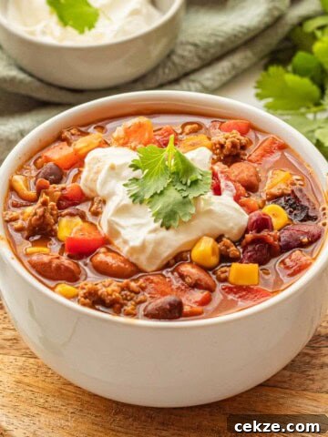Cooked healthy taco soup in white bowl with sour cream and cilantro on top.
