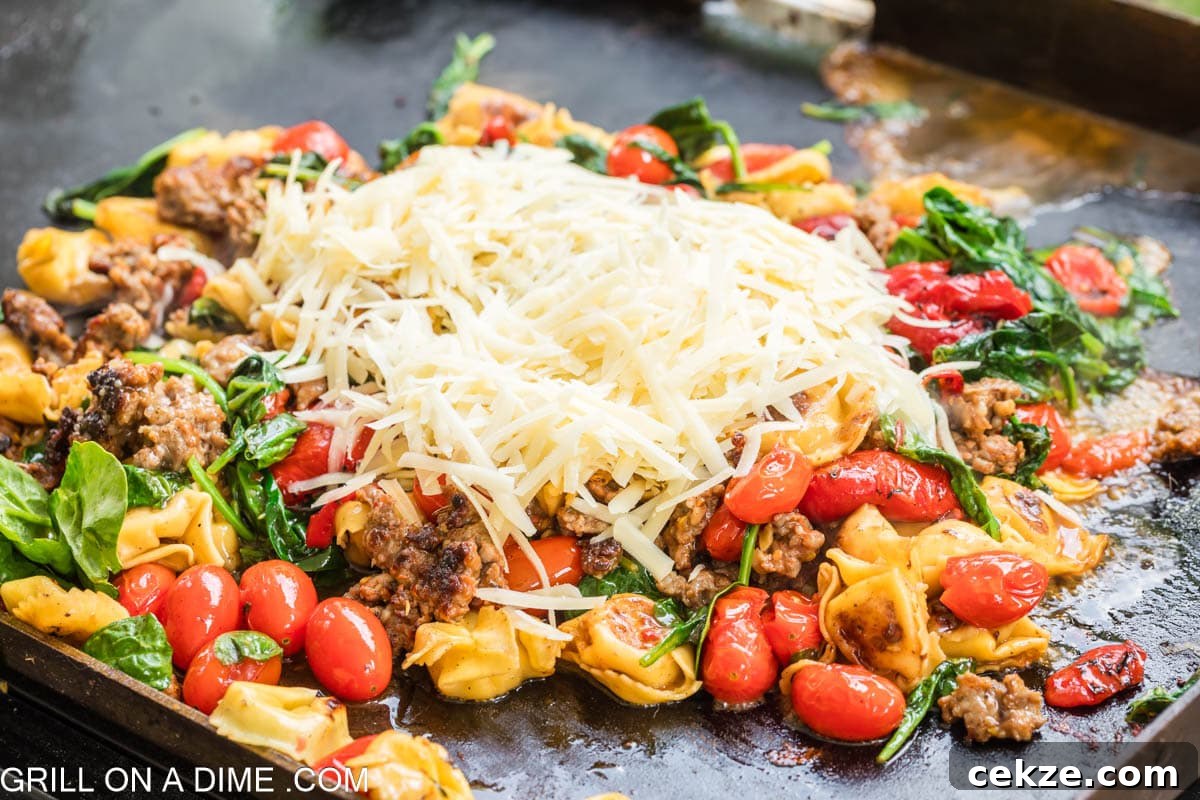 Shredded parmesan cheese on the cooked sausage, cherry tomatoes and fresh spinach