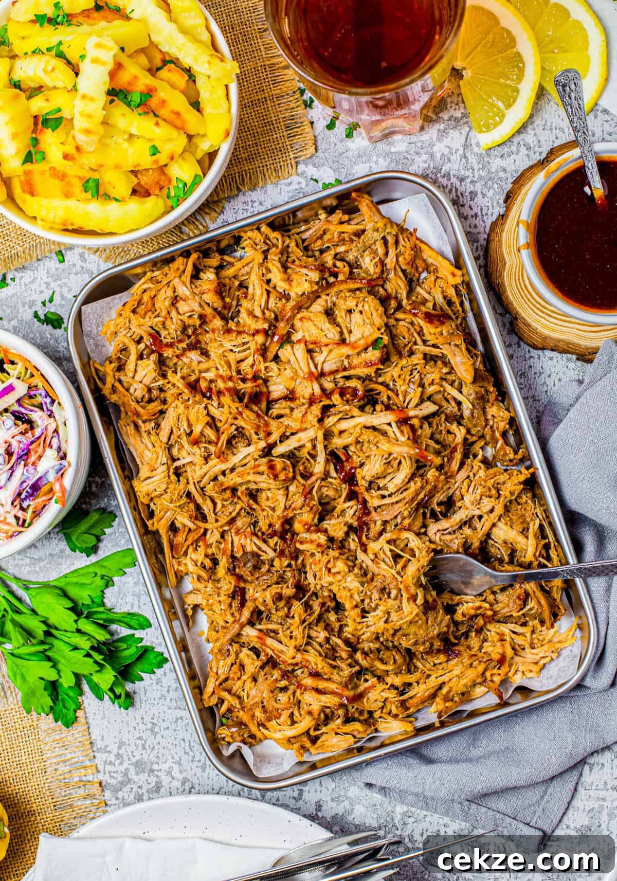 Tender Slow Cooker Pulled Pork Recipe for Sandwiches 3 Overhead of Pulled Pork on tray with fork and side dishes