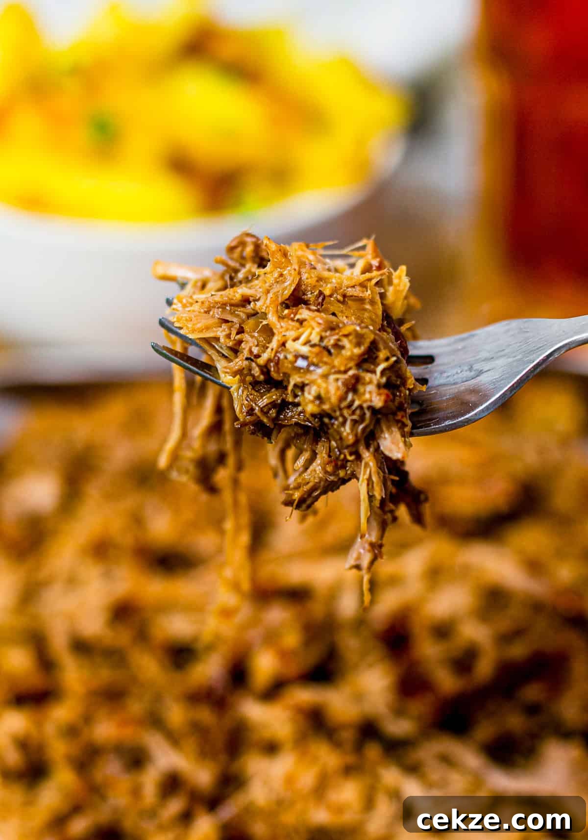 Tender Slow Cooker Pulled Pork Recipe for Sandwiches 7 Fork holding up some of the Crock Pot Pulled Pork