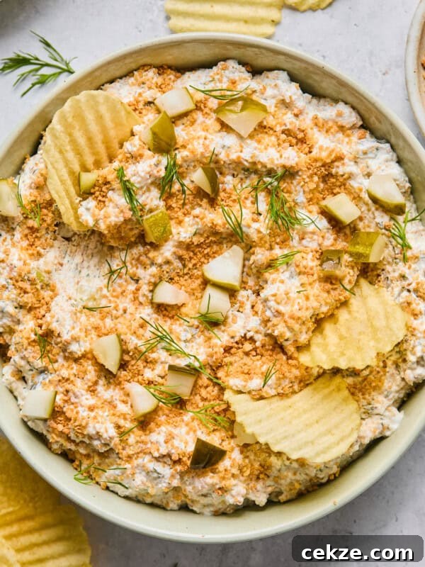 fried pickle dip in a light green bowl surrounded by potato chips