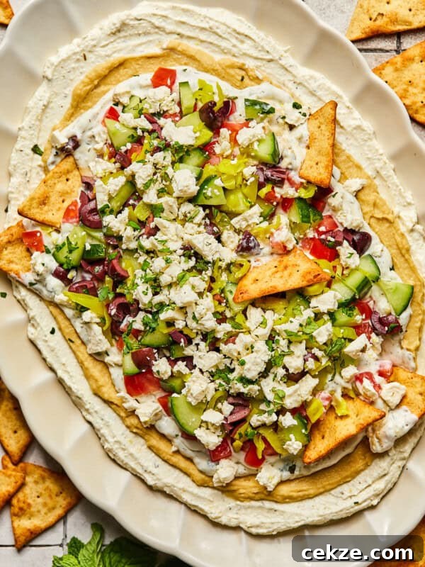 7 layer Greek dip on a platter with pita chips