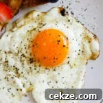 Perfect Sunny-Side-Up Eggs: Step-by-Step Cooking Guide 5 Closeup of a sunny side up egg with Maldon salt and pepper.