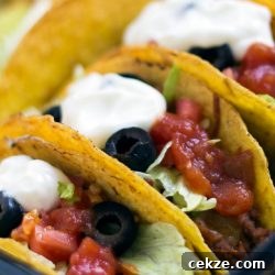 Hard-shell tacos with beef, lettuce, olives, salsa, and sour cream