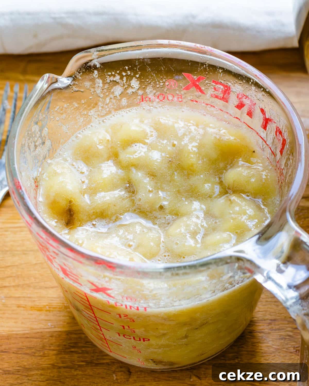 Mashed bananas in a measuring cup.