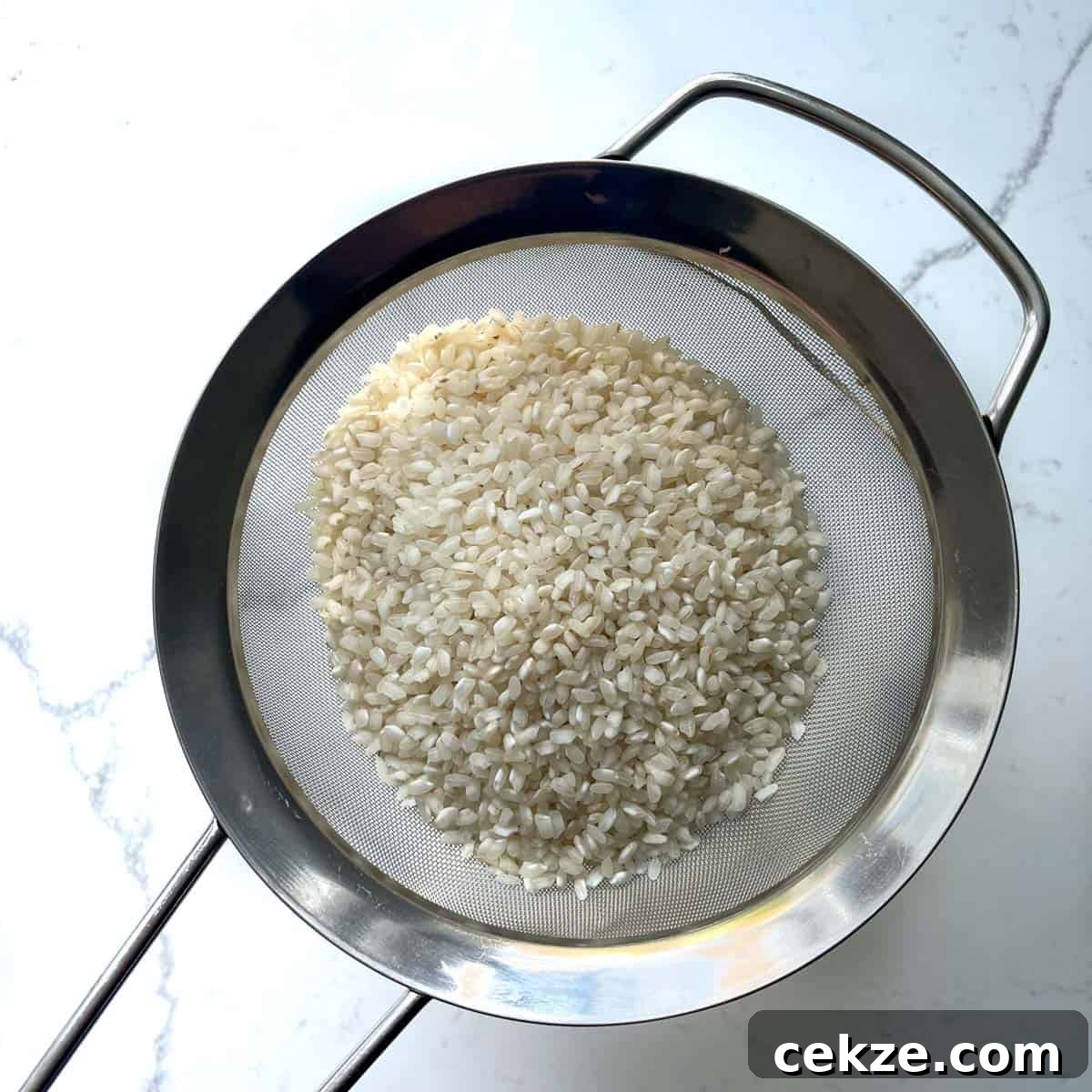 Authentic Egyptian Rice with Toasted Vermicelli Recipe 5 Adding rice to a fine mesh sieve for rinsing.