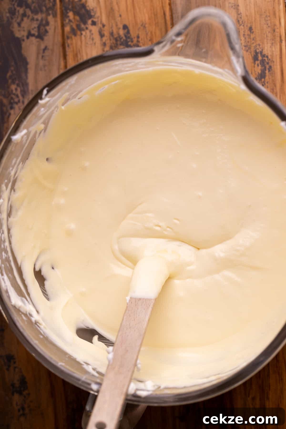 Carrot Cake Cheesecake Recipe: Moist Layered Dessert with Cream Cheese Frosting 4 Cheesecake batter in a glass bowl.