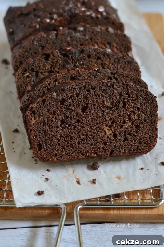 Chocolate Zucchini Bread with Less Sugar and Moist Texture 4 Slices of chocolate zucchini bread on parchment paper