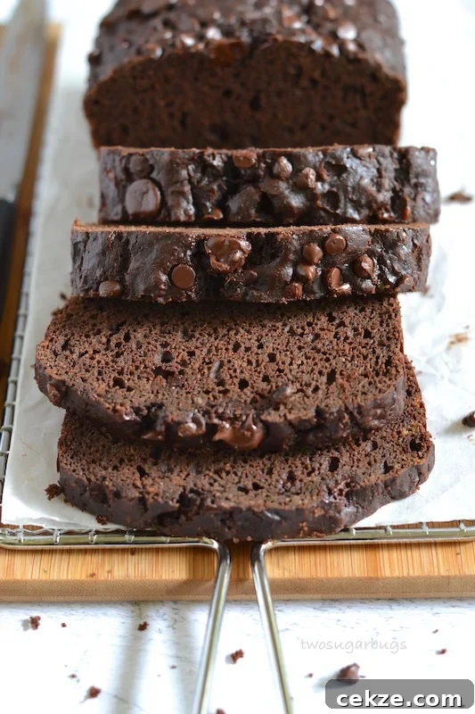 Chocolate Zucchini Bread with Less Sugar and Moist Texture 5 Slices of chocolate zucchini bread on a cutting board and cooling rack
