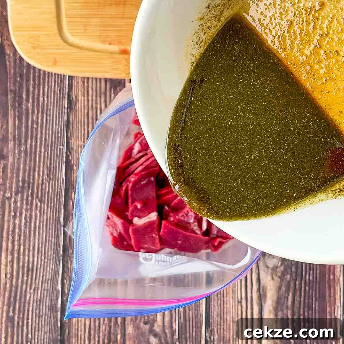 The marinade being poured over top of the venison strips.
