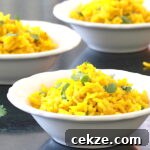 Three small bowls of rice with turmeric garnished with cilantro
