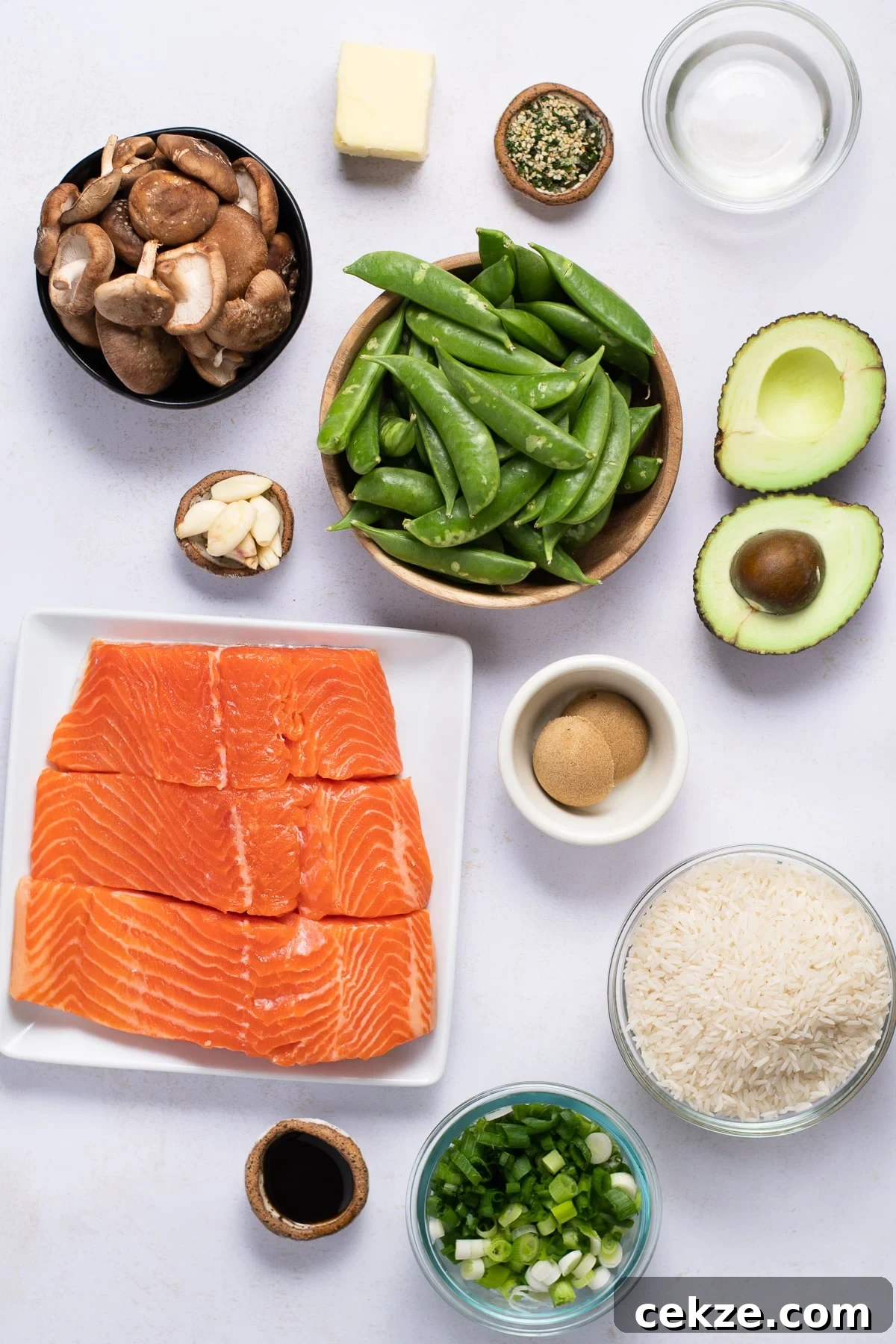 Ingredient shot with salmon, garlic, snap peas, shiitake mushrooms, avocado, brown sugar, rice, butter, mirin, furkikake seasoning, green onions and soy sauce