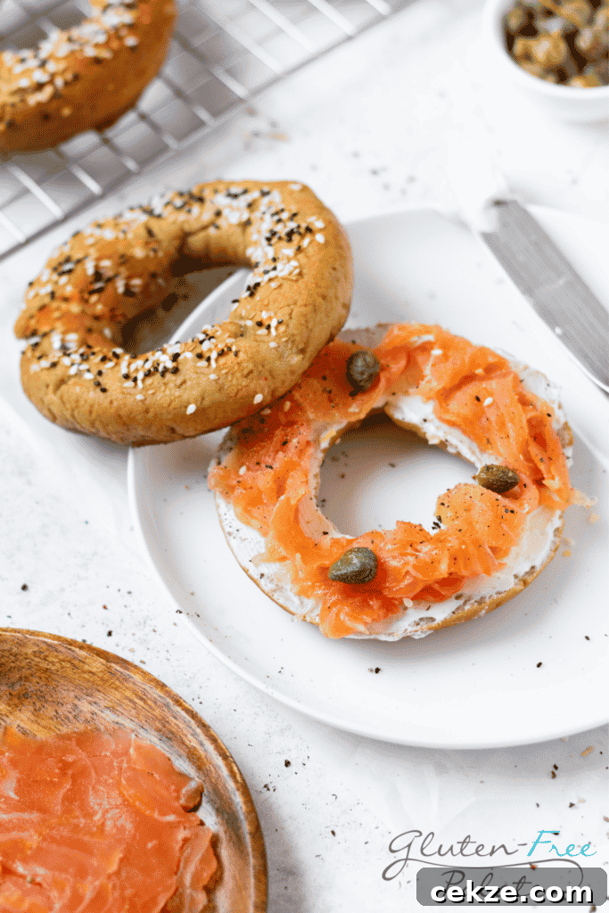 a sliced bagel on a plate topped with cream cheese, lox, and capers.