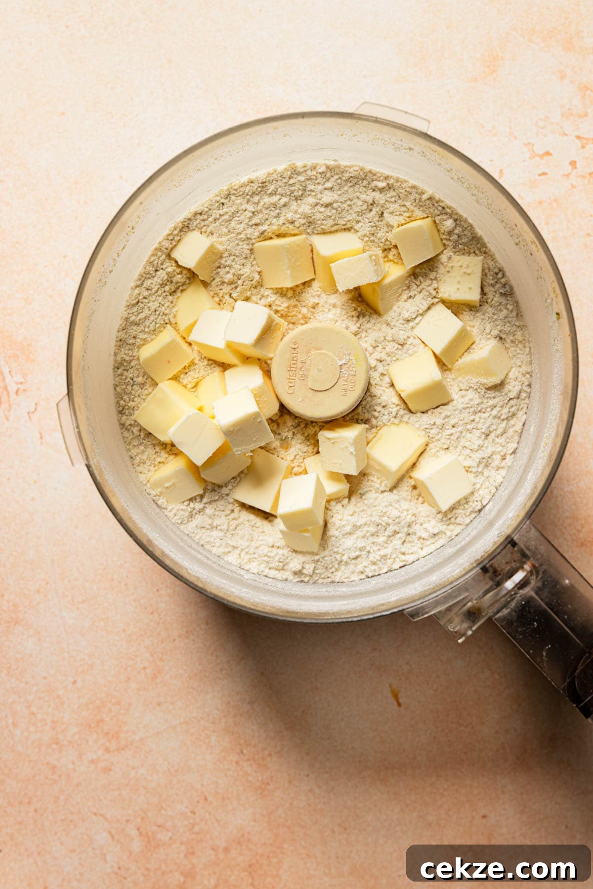 a food processor bowl with flour and butter.