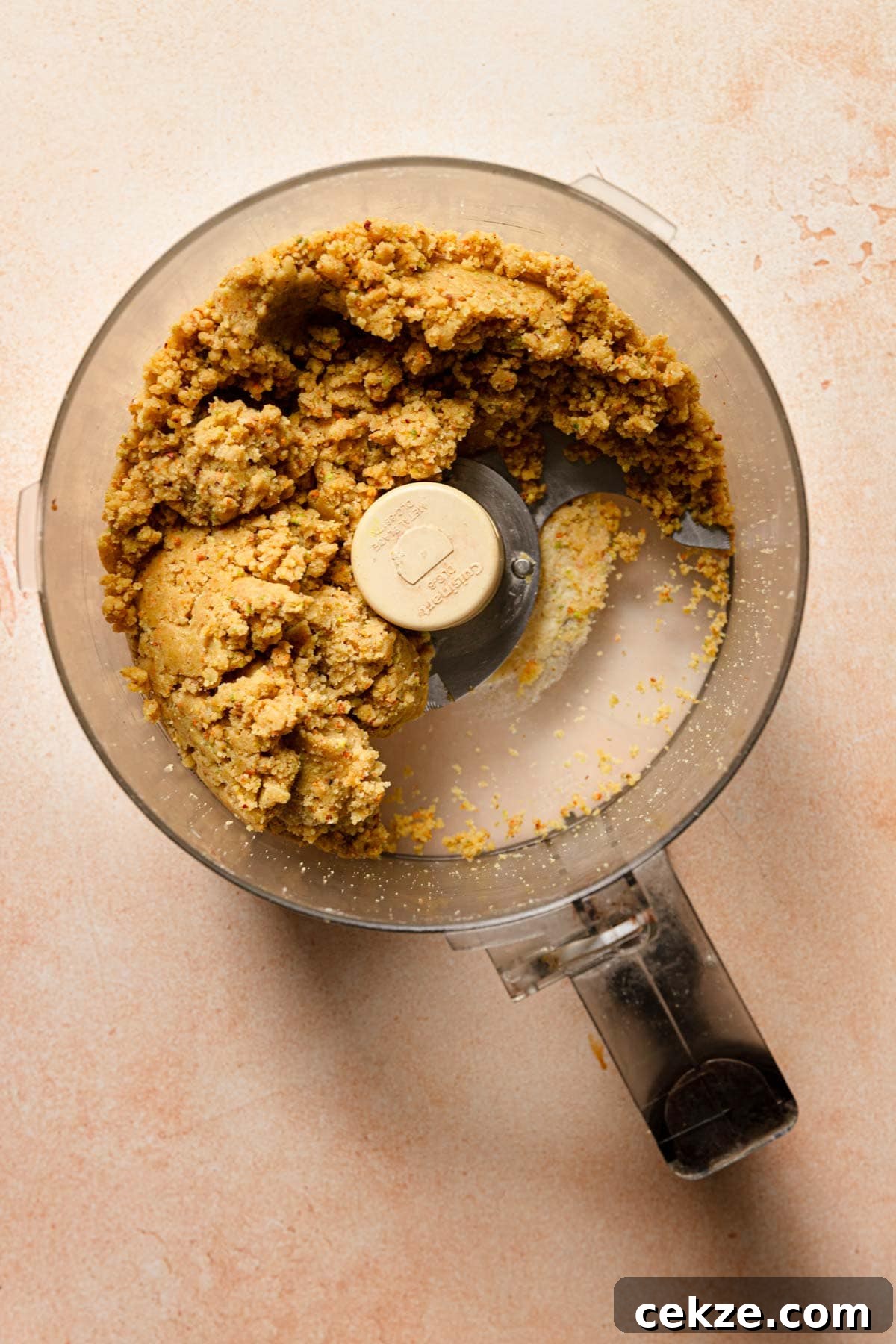 a food processor bowl with pistachio cookie dough.