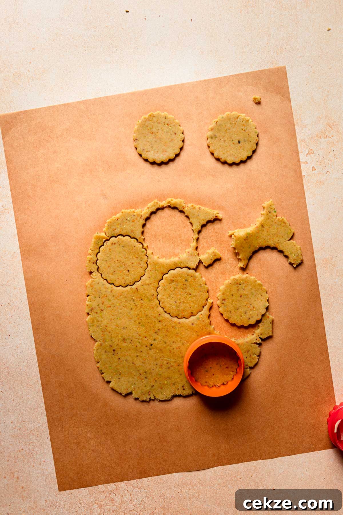 Parchment paper with rolled dough and a cookie cutter.