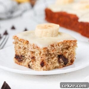 A piece of banana slice, sitting on a small round white plate.