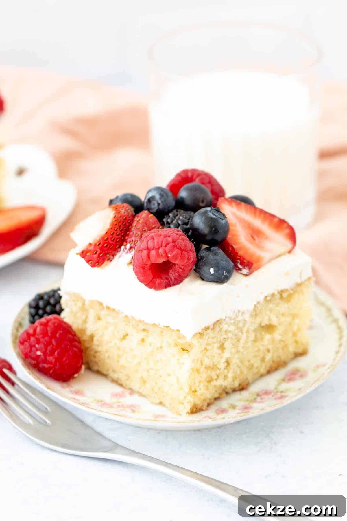 slice of vanilla cake topped with whipped cream and fresh berries