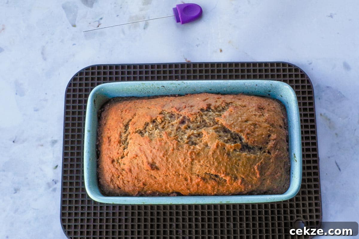 Tropical Banana Bread with Lime Glaze Recipe 11 Baked Tropical Banana bread, in loaf pan, on black rectangular trivet.