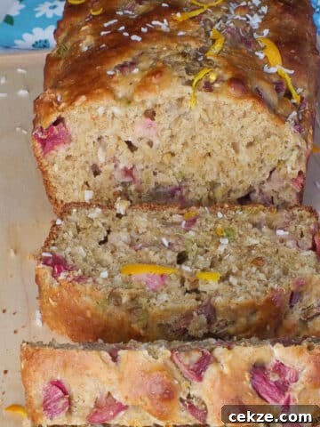 healthy rhubarb bread on a cutting board with 3 pieces sliced