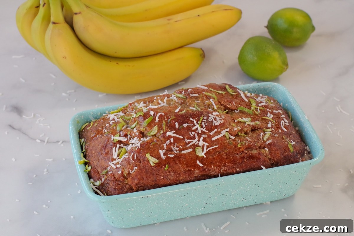 Tropical Banana Bread with Lime Glaze Recipe 4 Tropical banana bread in blue loaf pan with bananas and limes in background