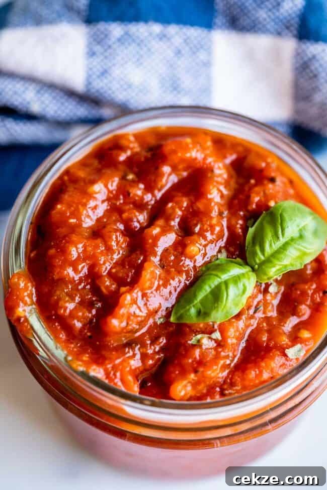Classic Homemade Pizza Sauce Recipe for Perfect Pies 10 homemade pizza sauce in a jar with basil garnish.
