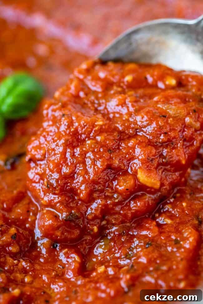 Classic Homemade Pizza Sauce Recipe for Perfect Pies 11 lifting a spoon of pizza sauce from the pan.