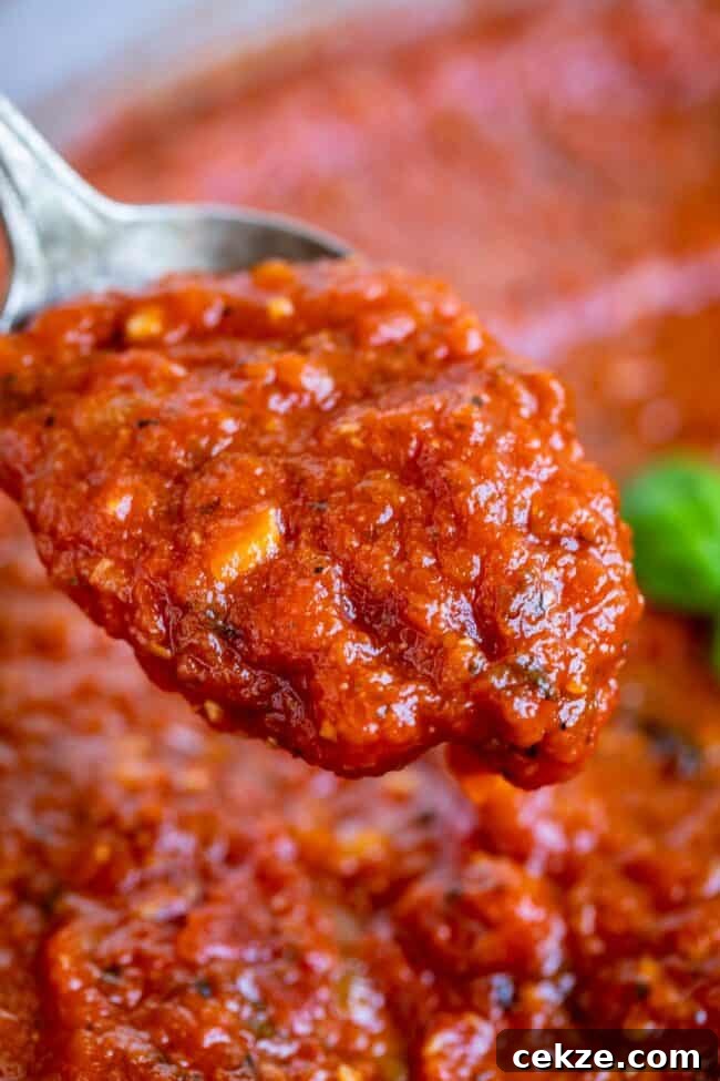 Classic Homemade Pizza Sauce Recipe for Perfect Pies 4 spoonful of pizza sauce held up.