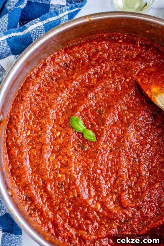 Classic Homemade Pizza Sauce Recipe for Perfect Pies 7 pizza sauce from scratch in a pan with basil garnish.