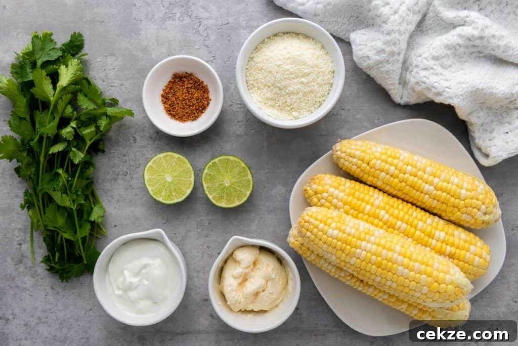 Authentic Elotes Recipe: Mexican Street Corn with Cotija & Lime 3 elotes ingredients on grey countertop