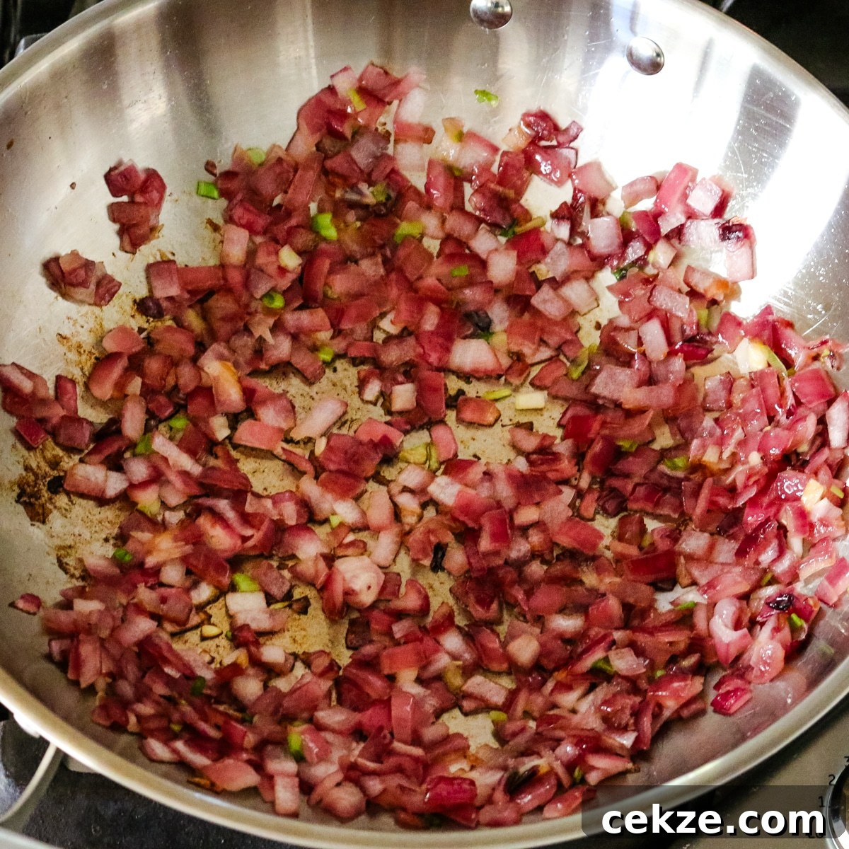 Keto Egg Roll in a Bowl Recipe: Quick Low-Carb Stir-Fry 5 sauteed red onions in a large wok for making egg roll in a bowl.