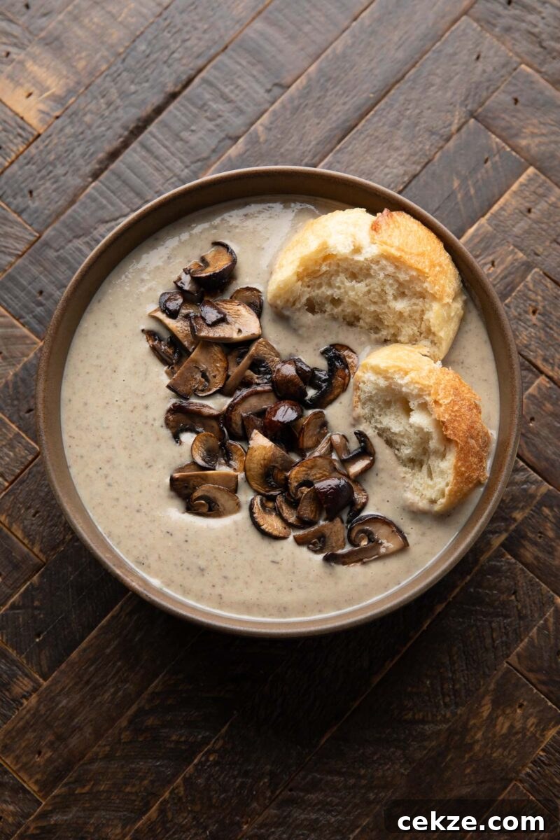 Bowl of Mushroom and Bean Soup with torn baguette and sliced mushrooms on top