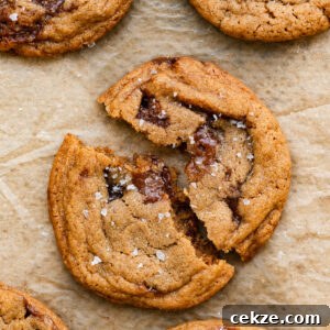 Brown Sugar Toffee Cookies Recipe — Chewy Caramelized Treats 10 Closeup of a toffee cookie broken in half on a piece of parchment paper.