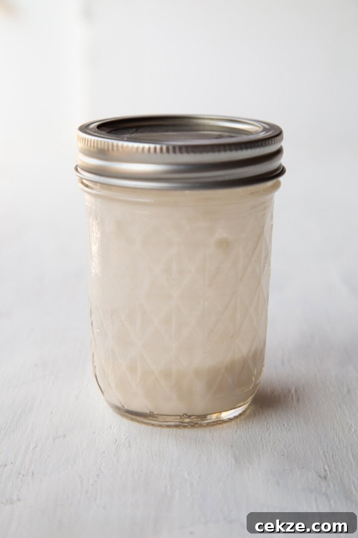glass jar with a flour and water mixture inside.
