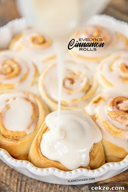 pouring icing on homemade cinnamon rolls