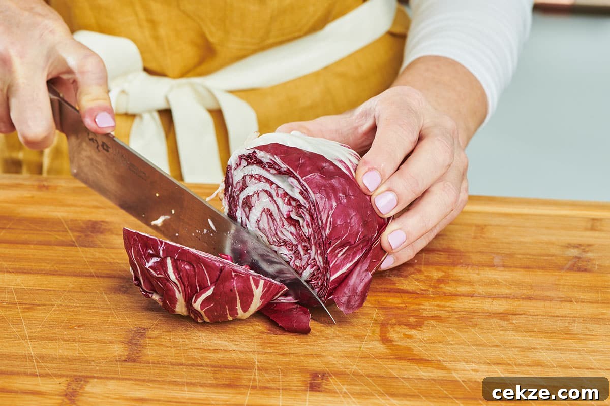 Cutting radicchio on board with knife.