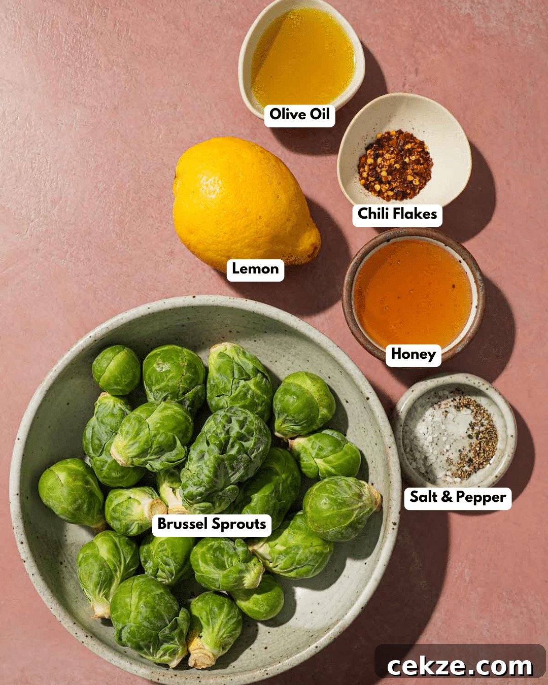 Roasted Hot Honey Brussels Sprouts (5-Ingredient Recipe) 3 Bowl of Brussels sprouts with lemon, olive oil, chili flakes, honey, salt, pepper.
