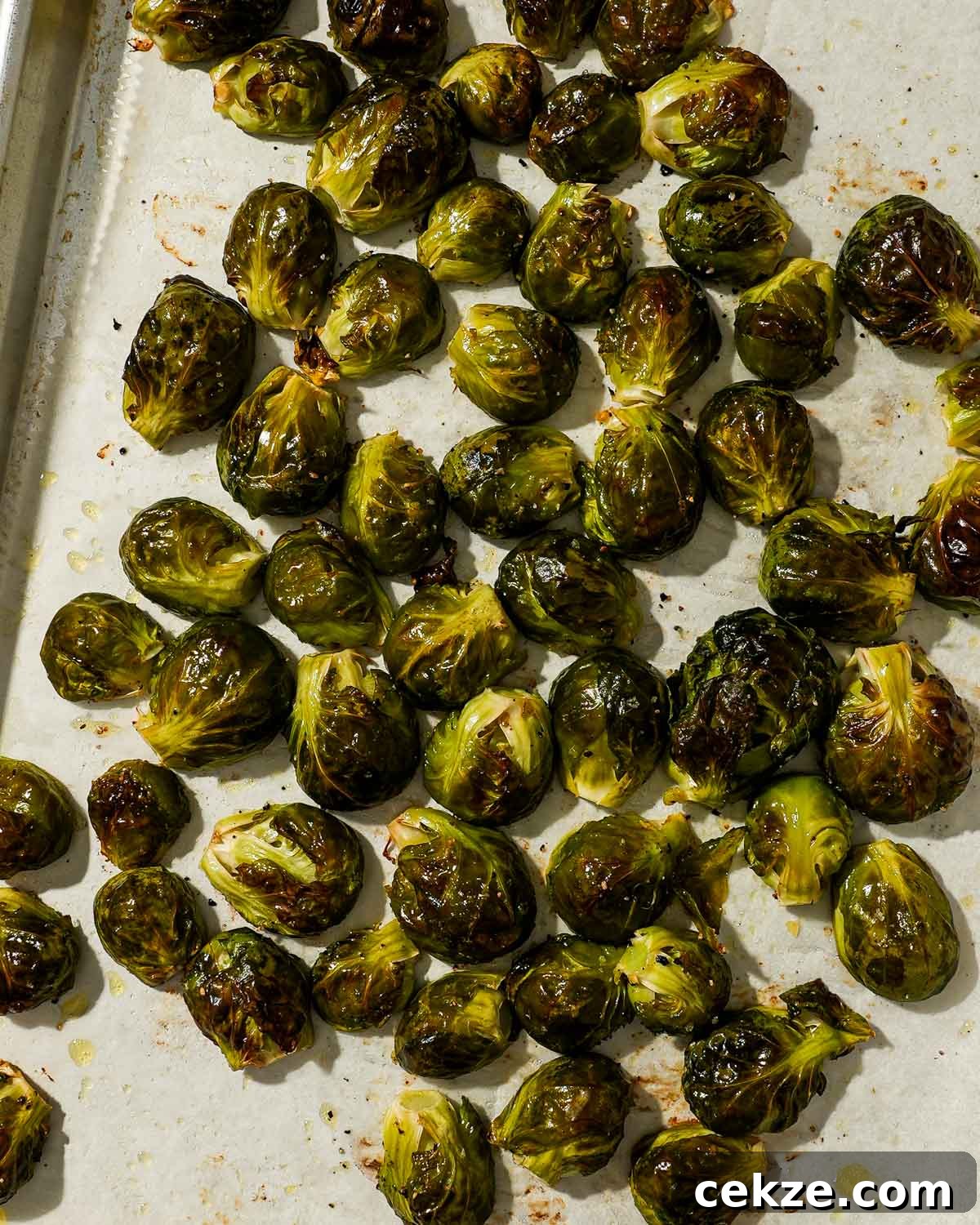 Roasted Hot Honey Brussels Sprouts (5-Ingredient Recipe) 5 Tray of whole roasted Brussels sprouts with golden, blistered outer leaves.