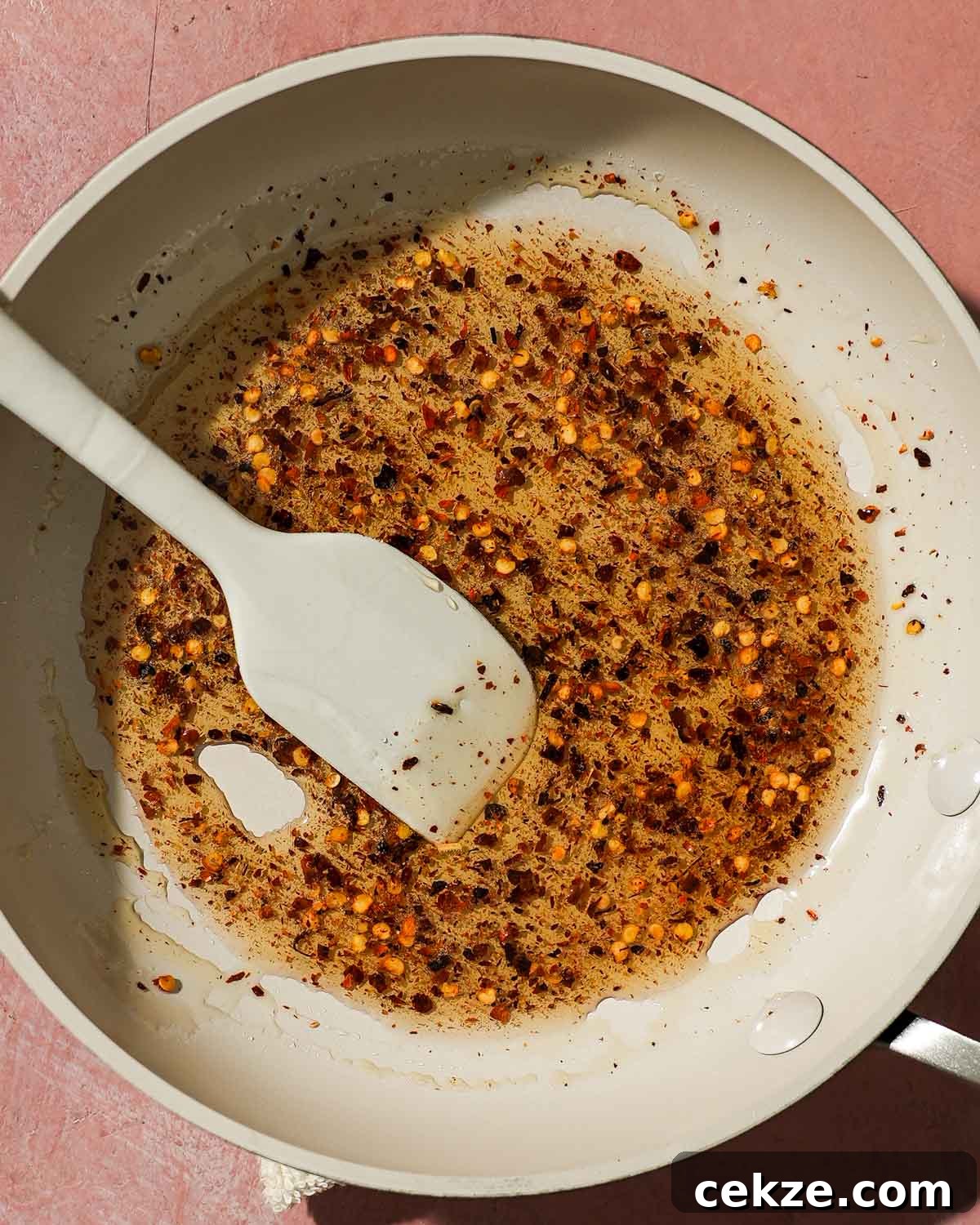 Roasted Hot Honey Brussels Sprouts (5-Ingredient Recipe) 6 Skillet with chili flakes and oil mixture for hot honey sauce.