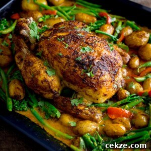 Curry-Roasted Chicken with Crispy Skin and Aromatic Spices 12 Curry roast chicken in a baking tin with potatoes, vegetables and curry sauce.