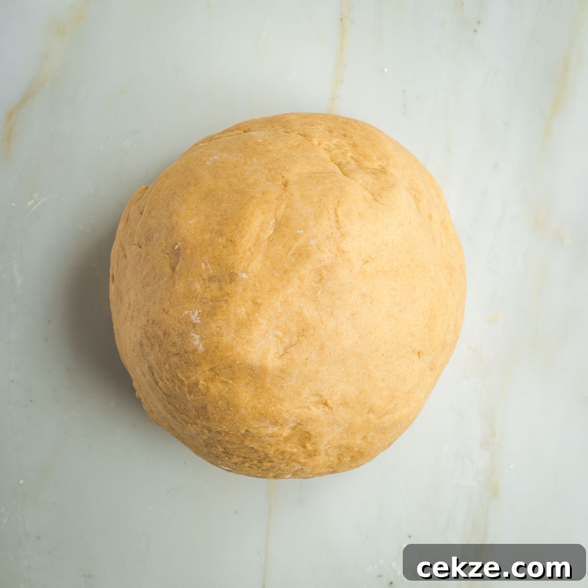 Sweet Round Challah Recipe: Soft, Shiny Braided Dinner Bread 18 Smooth, round ball of bread dough on a marble countertop.